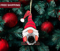 Red and green Santa Cam gnome ornaments hanging on a Christmas tree, perfect for fun holiday decorations.