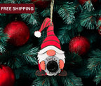 Red and green Santa Cam gnome ornaments hanging on a Christmas tree, perfect for fun holiday decorations.